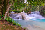 Fototapeta Las - Magical turquoise blue colours of Kuang Si waterfalls Luang Prabang Laos. these waterfalls in the Mountains of Luang Prabang Laos flow all year round in the natural national park rainforest 
