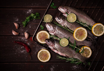 Raw rainbow trout, with lemon and herbs, on a wooden table, no people,