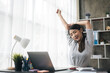 Young business women is relaxing and stretching while working on laptop in office space.