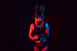 sexy mistress girl in beautiful underwear and a hare mask holds a leather flogger whip for BDSM sex with domination and submission