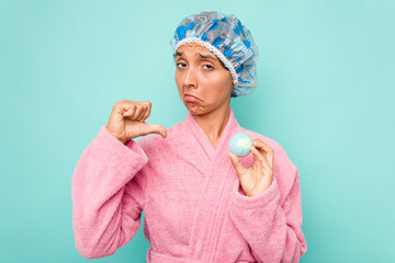 Wall Mural - Young hispanic woman holding bathtub ball isolated on blue background feels proud and self confident, example to follow.