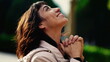 © Marco - A grateful hispanic woman praying to God with hands clenched looking at sky smiling. Spiritual person having HOPE