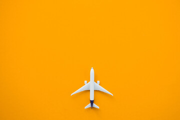 Wall Mural - Flat lay design of travel concept with plane on yellow background