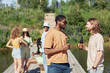 © Seventyfour - Side view portrait of two young men drinking beer outdoors in Summer and chatting