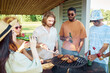 © Seventyfour - Diverse group of friends grilling meat during barbeque party outdoors in Summer and drinking beer