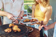 © Seventyfour - Close up of friends grilling chicken meat during barbeque party outdoors in Summer