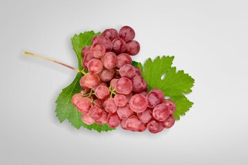 Wall Mural - Red grapes with green leaves on background.