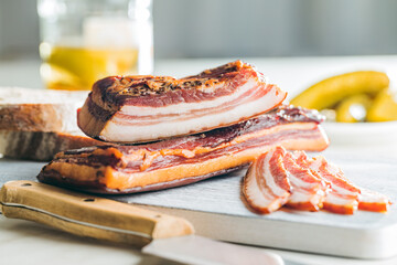 Wall Mural - Sliced smoked bacon on cutting board.