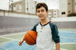 © kleberpicui - Portrait of 12 year old boy with basketball. Teenager training basketball outdoors.