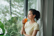 © Marc Tran/Stocksy - Young beautiful woman with glass of juice