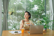 © Marc Tran/Stocksy - Smiling young asian woman having healthy lunch at office desk
