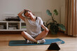 © Lyuba Burakova/Stocksy - Woman doing stretching neck at home