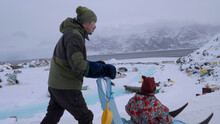 Inuit Dad Pushes Daughter On Sledge Past Uummannaq Harbor Ice Hinge
