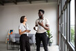 © Valentina Barreto/Stocksy - Mixed colleagues talking at modern office