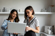 © Valentina Barreto/Stocksy - Women sharing laptop in office kitchen