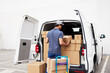 © ALTO IMAGES/Stocksy - Delivery man loading van on parking lot