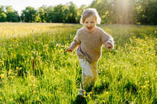 Child Running Along Path In Grassy Meadow