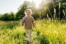 Kid Running In Grassy Meadow