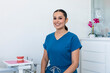© Shava Cueva/Stocksy - A smiling female dentist sitting in a chair
