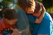 © Jelena Jojic Tomic/Stocksy - Kids play, wrestle, climb and annoy their father outdoors in a park