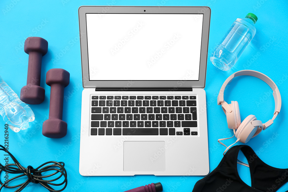 Composition with dumbbells, modern laptop, headphones and bottle of water on color background