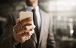 © Arnéll Koegelenberg/peopleimages.com - Businessman browsing on his phone online to look at his social media in the office, close up. Corporate professional in a suit reading a sms message. Male executive checking his news feed
