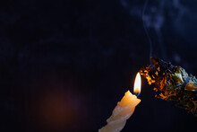 Herbal Wand Stick Above Burning Candle Isolated On Black