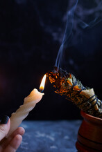 Herbal Wand Stick Above Burning Candle Isolated On Black