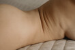 © Anastasia Mihaylova (Shpara)/Stocksy - Close up vertical photo of naked woman's skin Folds