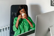 © David Prado/Stocksy - black woman drinking coffee while working on computer