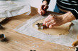© nomad studio/Stocksy - Woman cutting cookie dough with metal cutters.
