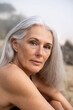 © Alba Vitta/Stocksy - Portrait of serene mature woman at the beach