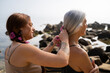 © Alba Vitta/Stocksy - Daughter braiding mother's hair in the beach