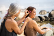 © Alba Vitta/Stocksy - Mother braiding hair to daughter at the beach
