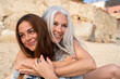 © Alba Vitta/Stocksy - Portrait of mature  mother and adult daughter at the beach