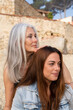 © Alba Vitta/Stocksy - Portrait of mature  mother and adult daughter at the beach