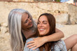 © Alba Vitta/Stocksy - Portrait of mature  mother and adult daughter at the beach