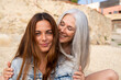 © Alba Vitta/Stocksy - Portrait of mature  mother and adult daughter at the beach