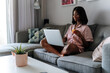 © David Prado/Stocksy - Black woman using laptop at home