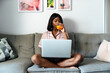 © David Prado/Stocksy - Black woman using laptop at home