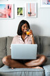 © David Prado/Stocksy - Black woman using laptop at home