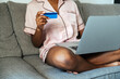 © David Prado/Stocksy - Crop woman with credit card using laptop