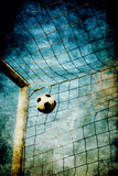 Fototapeta  - soccer post and ball into the net , with a gritty effect