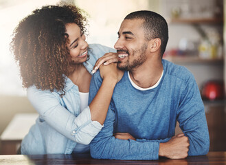 Poster - Loving, caring and smiling couple in a kitchen at home. Man and woman looking at each other in love, joy and happiness. Young romantic people having an affectionate moment together indoors