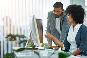 Poster - Professional businesswoman, designer or manager talking with worker at a workstation in an office. Teamwork during business meeting, working and communicating together in creative office.