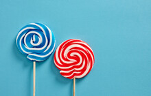 Colorful Swirl Round Candy Lollipops On Blue Background.