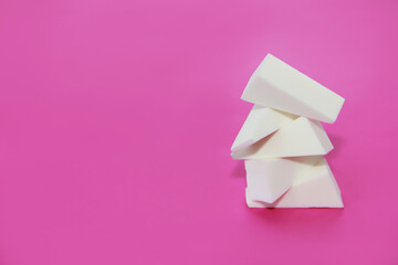 white cosmetic sponges for applying cream on a pink background