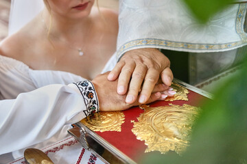 Wall Mural - During the church wedding, the bride and groom put their hands on the Gospel.