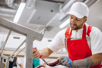 Man butcher at the freezer cutting meat