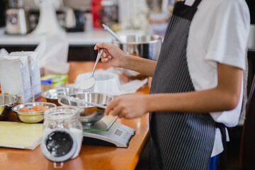 Young boy measuring ingredient for baking in kitchen.